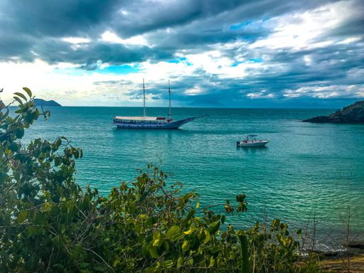 The boats sailing on the calm sea under the  beautiful, cloudy sky