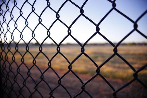 A closeup shot of wire fences in background of blurred dry land in Brentwood
