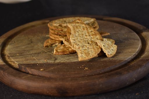 A closeup of crackers on a wooden board under the lights - perfect for food concepts