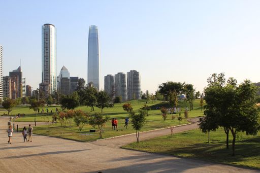 Perfect sunny day and blue sky in Santiago. Park view with big buildings in the back.