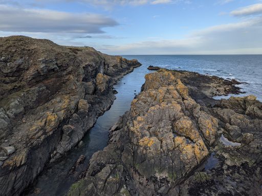 A small water stream originating from a sea flowing through the rocky shore