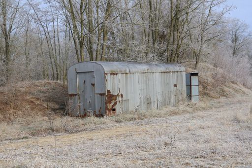 An eye-level shot of a rusty metal wagon trailer in the woods