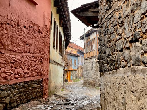 A narrow stone alley through historic buildings in Cumalikizik, Bursa, Turkey