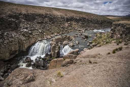 A mesmerizing shot of a wild waterfall under the cloudy vibrant sky