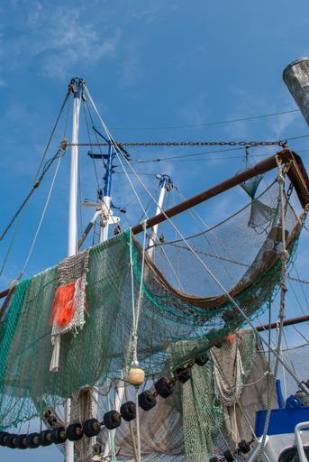 A low angle shot of nets hanging on trawlers of a fishing vessel