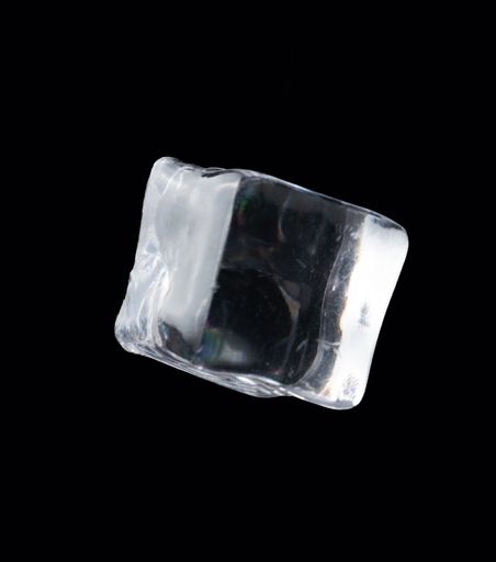 A closeup shot of a floating ice cube on a black background