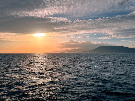 The sun setting down at the Aegean Sea after a cloudy day