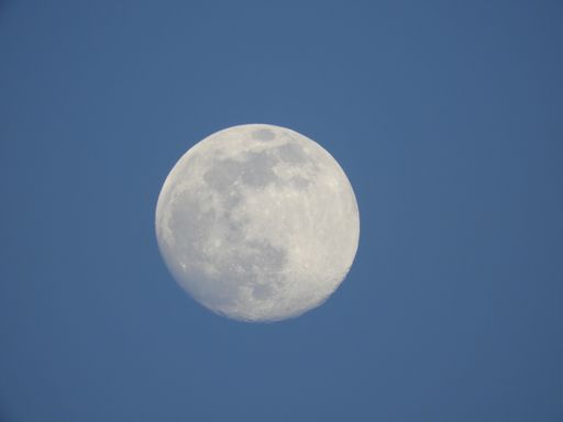 A low angle shot of the magnificent full moon in the clear blue sky
