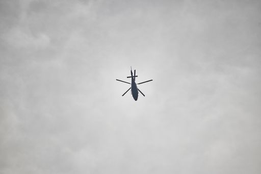 A low angle shot of a flying helicopter in a gray, foggy and cloudy sky