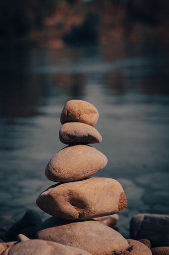 A vertical shot of a stack of pebbles isolated on a blurred background