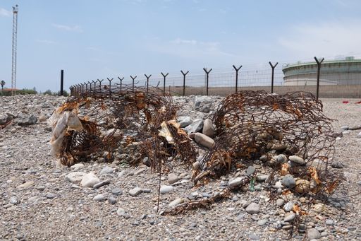 A sunny scenery of rusty metal fences garbage in a dirty territory