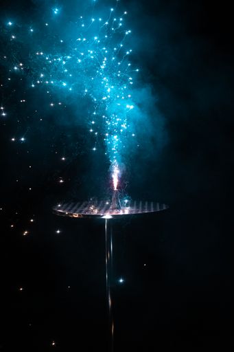 A blue firework released from a metal stage in the dark for the new year