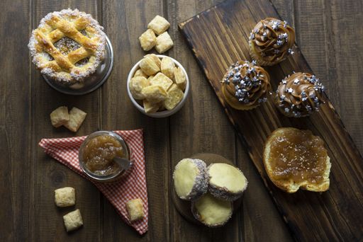 breakfast or snack table on rustic wooden table with zenith shot with pastafrola muffin maizena alfajores muffins with dulce de leche