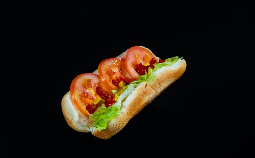 A closeup shot of a hotdog sandwich isolated on a black background