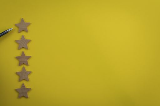 An overhead shot of a pen pointing at the highest star on the yellow background