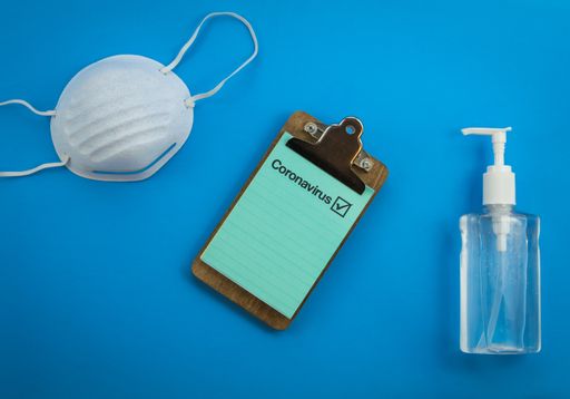 A prescription note next to a hand sanitizer and a medical mask
