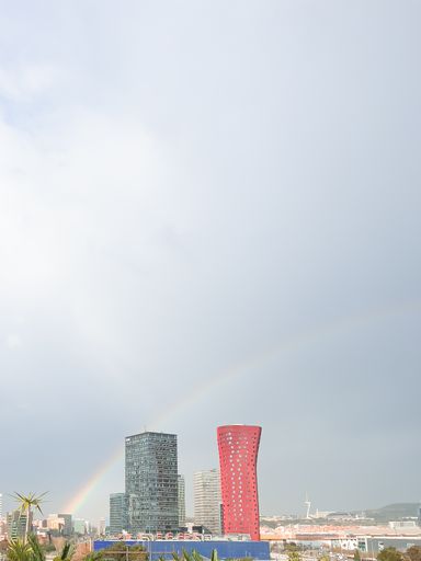 A magnificent vertical view of the rainbow in the landscape of Barcelona, during a stormy afternoon