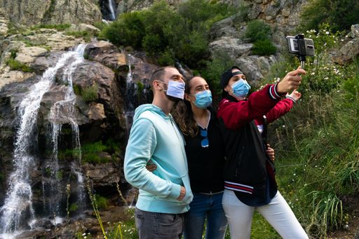A closeup shot of a group of friends wearing masks taking a selfie in nature