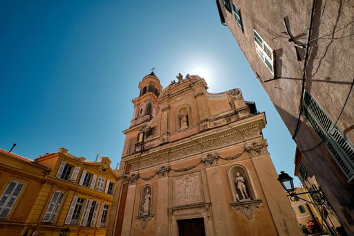 A horizontal low angle shot of a beautiful old building, bright sun and a clear sky in France