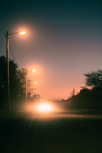 A vertical shot of car lights on the street at night
