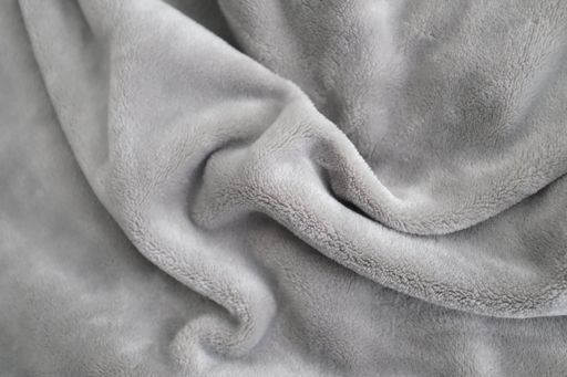 A closeup shot of a gray, soft and smooth texture throw blanket -- great for photo manipulation & 3d rendering material