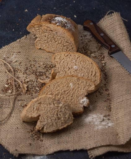 The delicious, crusty sliced bread on a fabric with a knife