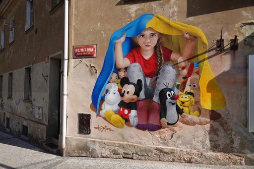 Mural of girl with toys hidding under Ukrainian flag by Czech street atrist of Kazakh origin Chemis in Mojmirova street in Prague 4 Nusle.