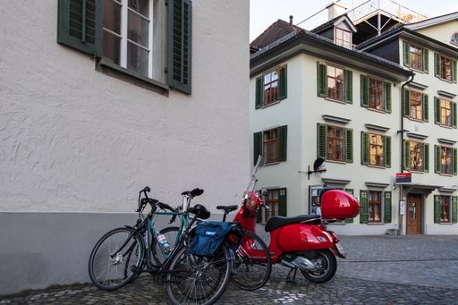 A blue bicycle and red moped on the street of Saint Gallen, Switzerland