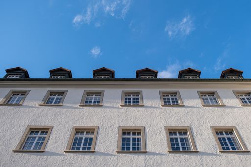 A low angle shot of a white building facade under a blue sky in St. Gallen, Switzerland