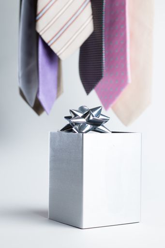 Close up of a silver gift on a white background with colorful ties.