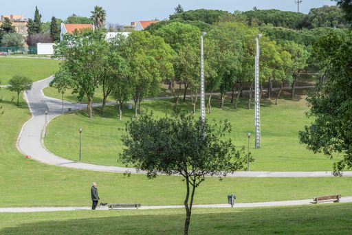 A senior man walking his dog in the Bela Vista Park garden in Lisbon, Portugal