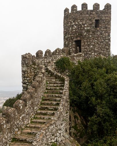 A closeup shot of a old historical stone wall with a stone tower