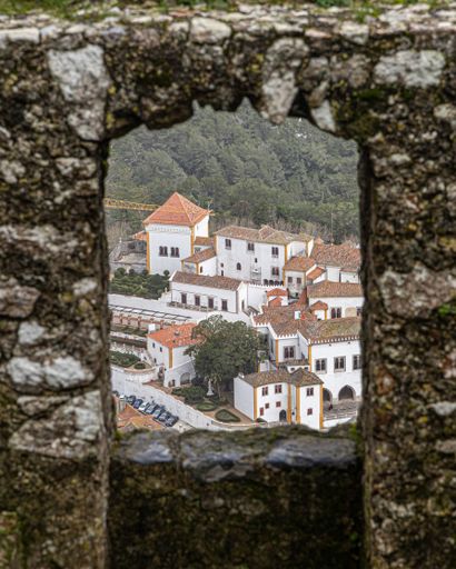 A vertical shot a of urban panorama photographed from a stone window