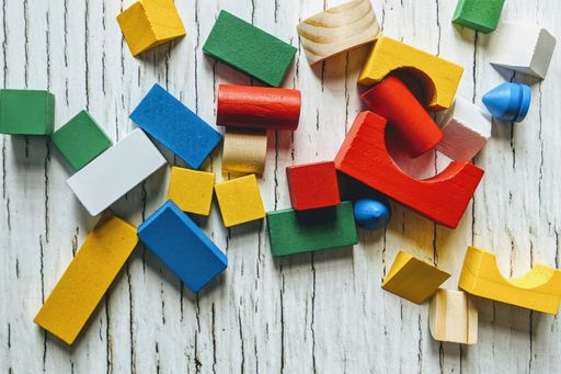 colourful multicoloured building wooden toy blocks geometric for kid learning development on rustic wooden table, top view flat lay copy space.