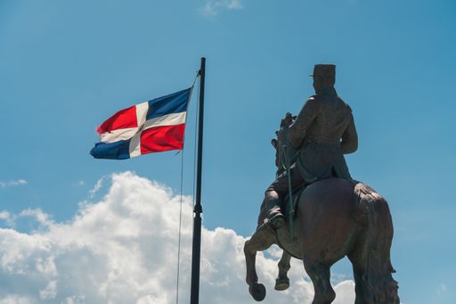 A closeup shot of the General Gregorio Luperon statue and the flag of Dominican Republic