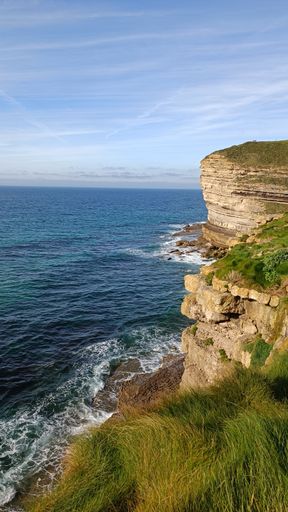 A vertical shot of waves washing the cliffs