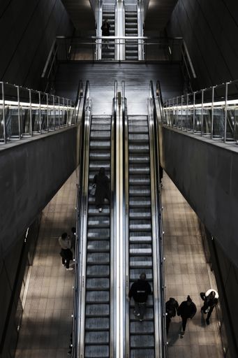 Overhead shot of an escalator at a train station with people on it