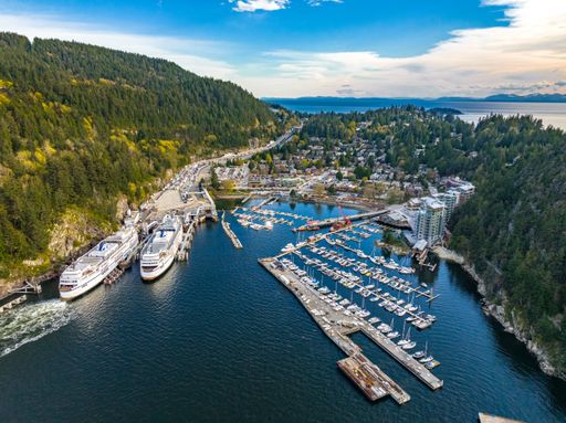 An aerial shot of the city, dense forest and moored boats and ferries at the harbor of Horseshoe Bay, West Vancouver, British Columbia, Canada