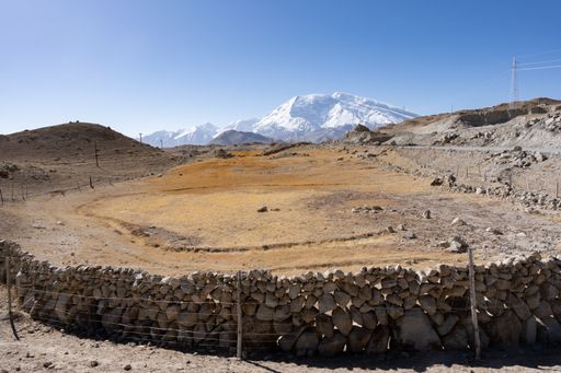 a shot of desert field agaisnt snow covered mountains