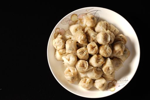 A top view of chicken strudels on the white plate isolated on the black background
