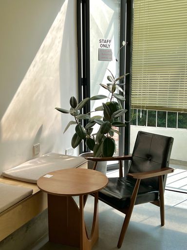 A vertical shot of a cozy corner in the office with a small round table and a leather chair