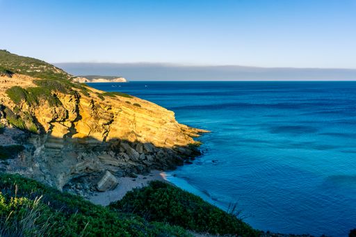 A high angle shot of rocky beach coast in golden sunlight in Figueira, Portugal