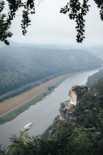 Photo at the Saxon Switzerland national park on a misty day with incredible rock formations shooting up from the ground