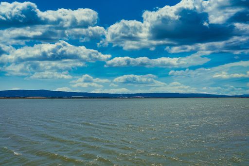 A breathtaking view of the sea under the blue sky with fluffy clouds on a sunny day
