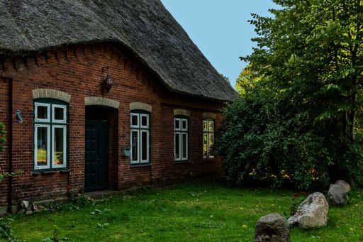 A beautiful shot of an old brick house with a cute green lawn in the front