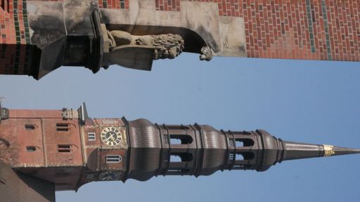 A vertical shot of St. Michael's Church with a clock tower in Hamburg, Germany, with a lion's statue