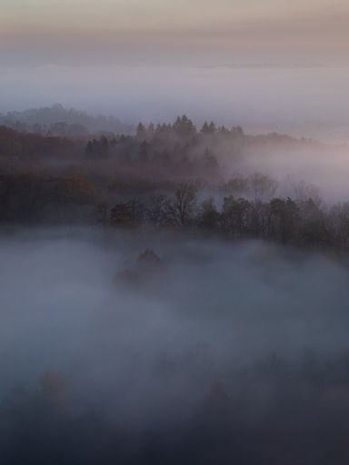 A vertical shot of mountains with the sea of clouds during sunset