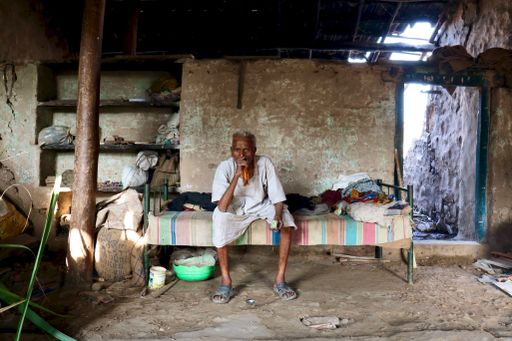 A selective focus of an Indian poor village old man in village attire in his house.