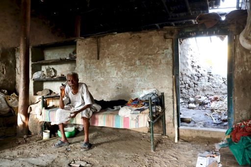 A selective focus of an Indian poor village old man in village attire in his house.