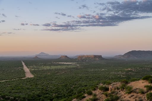 Namibia, landscape in Damaraland, with big rocks and a dirt road at sunset